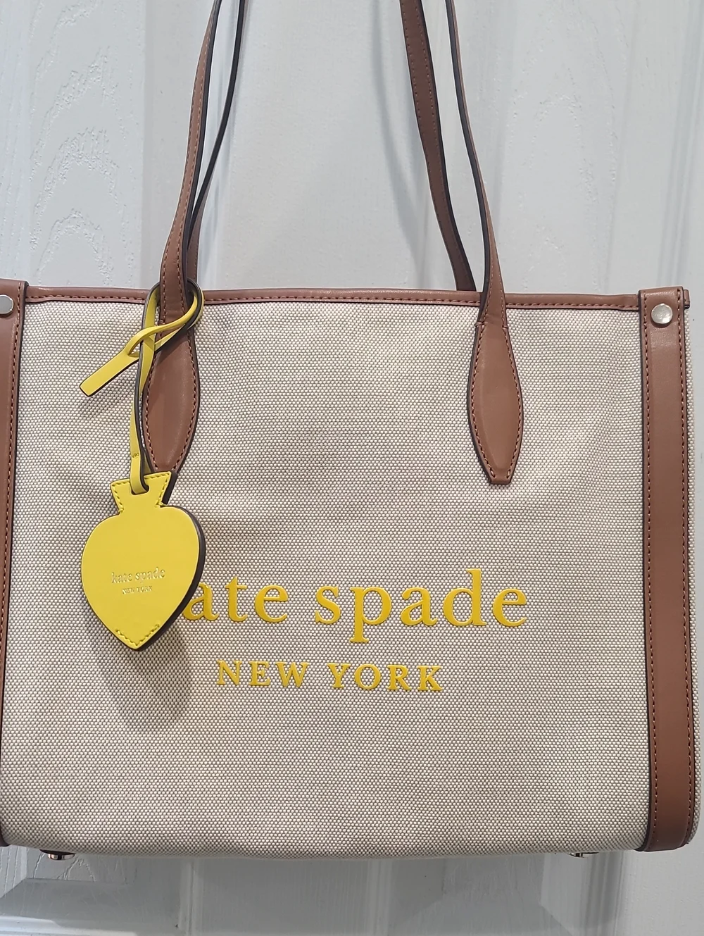 kate spade Beige Canvas Tote with Brown Trim and Yellow Charm